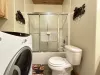 Basement shared bathroom with shower tub combo, toilet, and sink vanity.