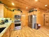 Enjoy modern cooking convenience surrounded by rich, authentic wood cabinetry and premium stainless steel appliances, including a spacious French-door fridge.