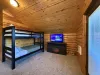 Upstairs loft with a single on single bunk bed with a smart tv and electric fireplace.