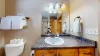 Equipped with shower tub combo, toilet, and sink vanity.