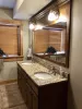 Basement ensuite bathroom with standing shower, sink vanity, and toilet.