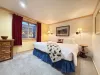 Large bedroom finished with a king size bed and end stand tables and dresser with a small closet.