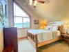 Enjoy peaceful mornings in this cozy upstairs bedroom, featuring a large geometric window that frames the beautiful outdoor scenery.