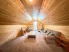 The spacious living area above the separate garage offers a cozy couch, armchairs, and a warm, rustic cabin atmosphere for extra privacy.