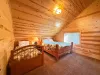 The second upstairs bedroom offers flexible sleeping options with a comfortable log Queen bed and a matching single twin bed side-by-side.