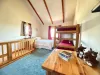 Open upstairs sleeping area with a queen bed and bunkbed.