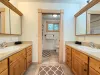 Loft bathroom with 2 vanities and sinks. Door between the sinks and bath/toilet area.