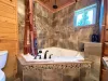 Unwind after a day of outdoor adventures in the deep jetted tub, beautifully styled with custom river-rock tiling and a premium overhead rain shower.