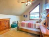 Bright and airy, this upstairs bedroom features vaulted ceilings and a large window that floods the space with beautiful natural light.