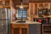 Kitchen with appliances, pots and pans, basic cooking essentials, dishes, and utensils.