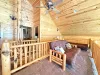 The open upstairs loft offers a versatile bonus space, featuring two comfortable futon sofas that easily convert into additional beds.