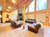 This breathtaking open great room boasts soaring vaulted ceilings and massive panoramic windows that perfectly showcase the beautiful natural surroundings.