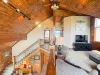 The grand loft area overlooks the main floor, showcasing the cabin's stunning vaulted architecture and rustic log railings.