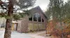 Welcome to North Big Springs Lodge! This stunning stone-accented cabin features beautiful geometric windows and is surrounded by lush, peaceful trees.