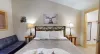 First bedroom with a king size bed, seating, and closet space.