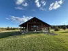 Lots of open grass surrounding the cabin.