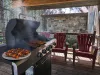 Propane grill on the front porch and seating.