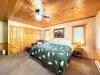 Master bedroom with a King size bed, armchair, and television.