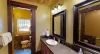 Upstairs shared bathroom equipped with shower/tub, toilet, and double sink.