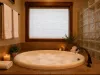 Indulge in a spa-like experience in the master bathroom, featuring a grand circular tub surrounded by warm candle light.